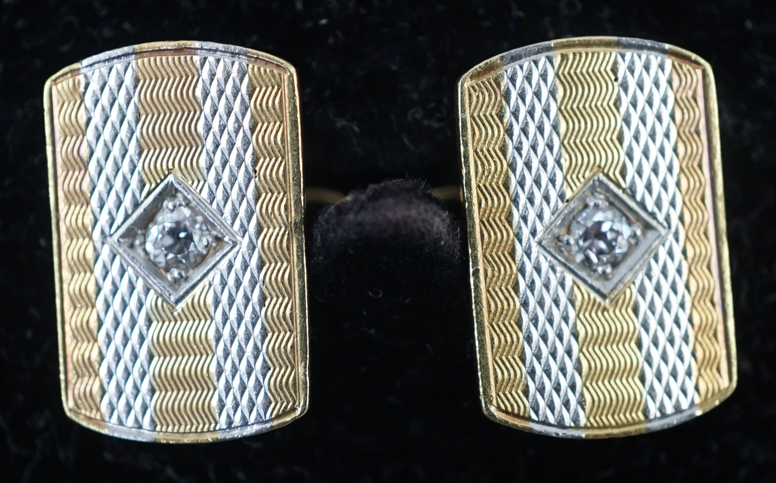 A pair of mid 20th century two colour 18ct gold and single stone diamond set cufflinks